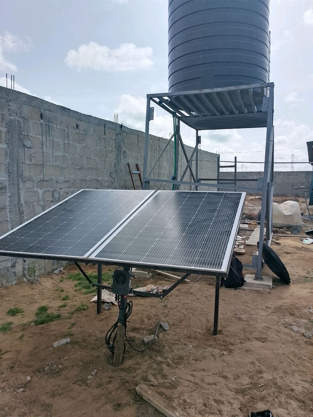 Installation de panneaux solaires au sol près d'un réservoir d'eau surélevé